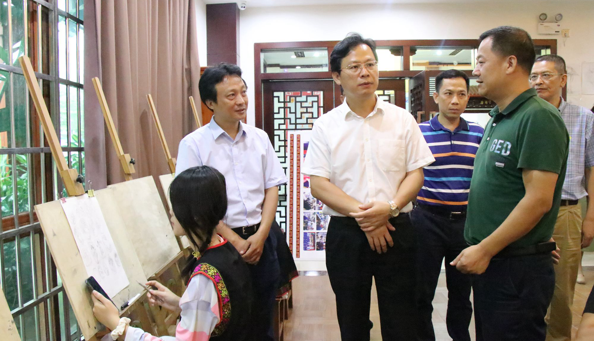 昌江黎族自治縣委書記陳儒茂（中）調(diào)研玉石雕刻工作。