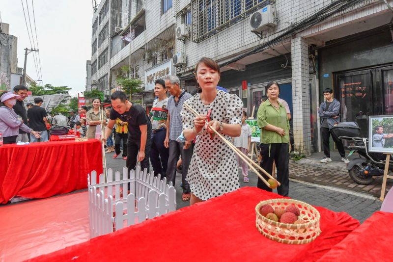 現(xiàn)場設置的“長筷夾荔枝”挑戰(zhàn)，緊張有趣。  主辦方供圖