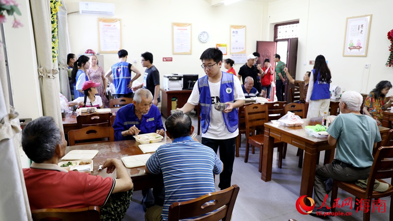 志愿者正在給用餐的老人盛湯。人民網(wǎng)記者 符武平攝