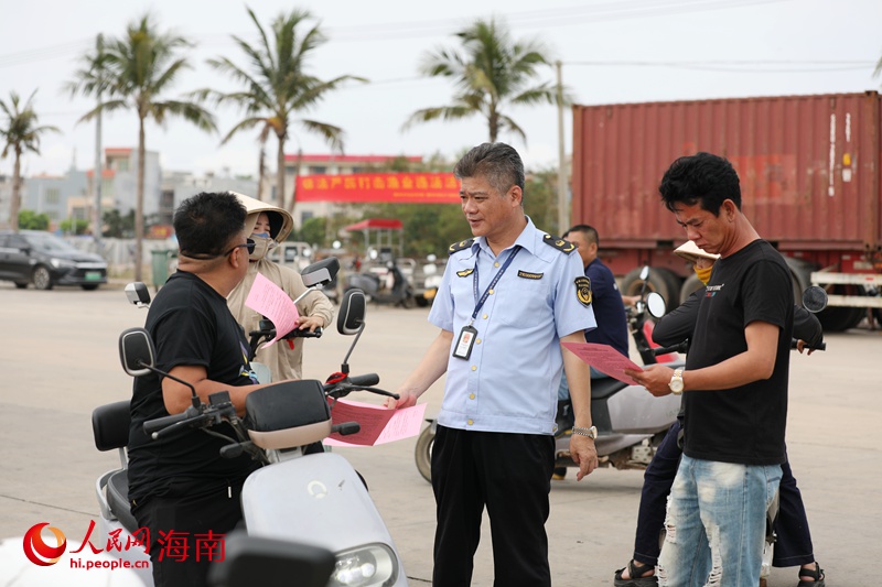 執(zhí)法人員給漁民發(fā)放休漁通告。人民網(wǎng)記者 符武平攝