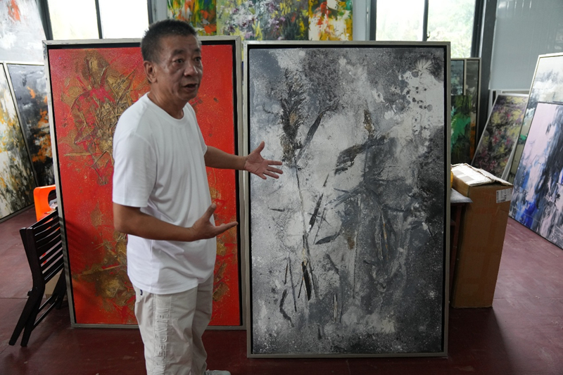 朱鯤向媒體記者介紹自己的作品。主辦方供圖